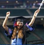 female in cap and gown celebrates at commencement ceremony 
