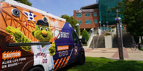 Astros Van sits in front of Marilyn Davies College of Business Building