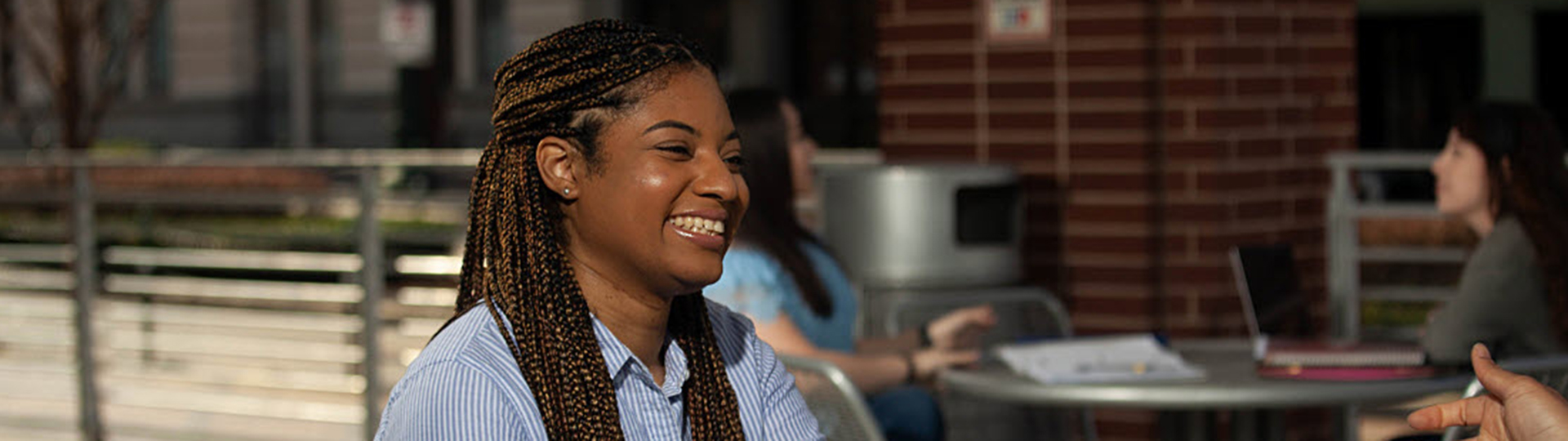 Female student sitting ourside smiling