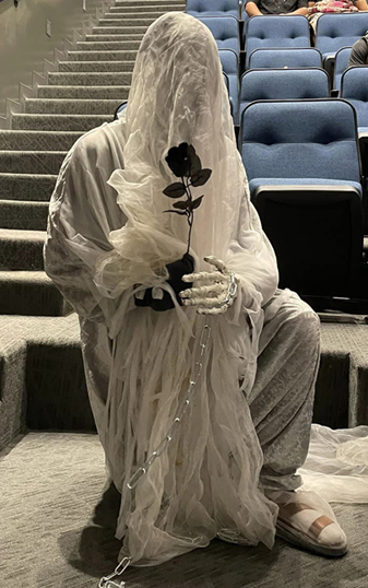 a person dressed as a ghost with a black rose