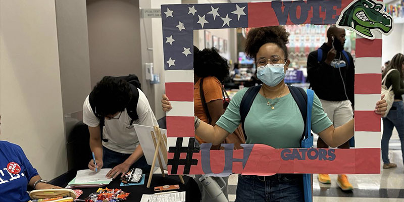 A student with  Empowered Youth with a vote photo prop.