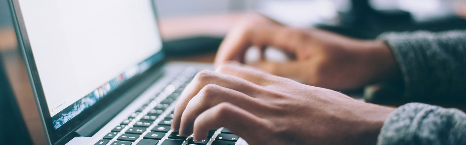 Hands typing at a computer