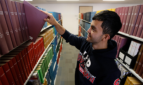 Student selecting a book from the stacks student selecting a book from the stacks