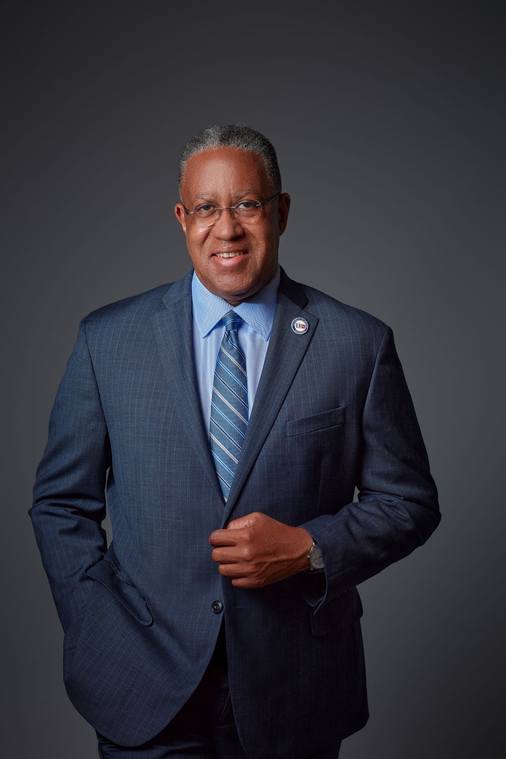 President Blanchard portrait. He is wearing a blue suit, shirt, and tie.