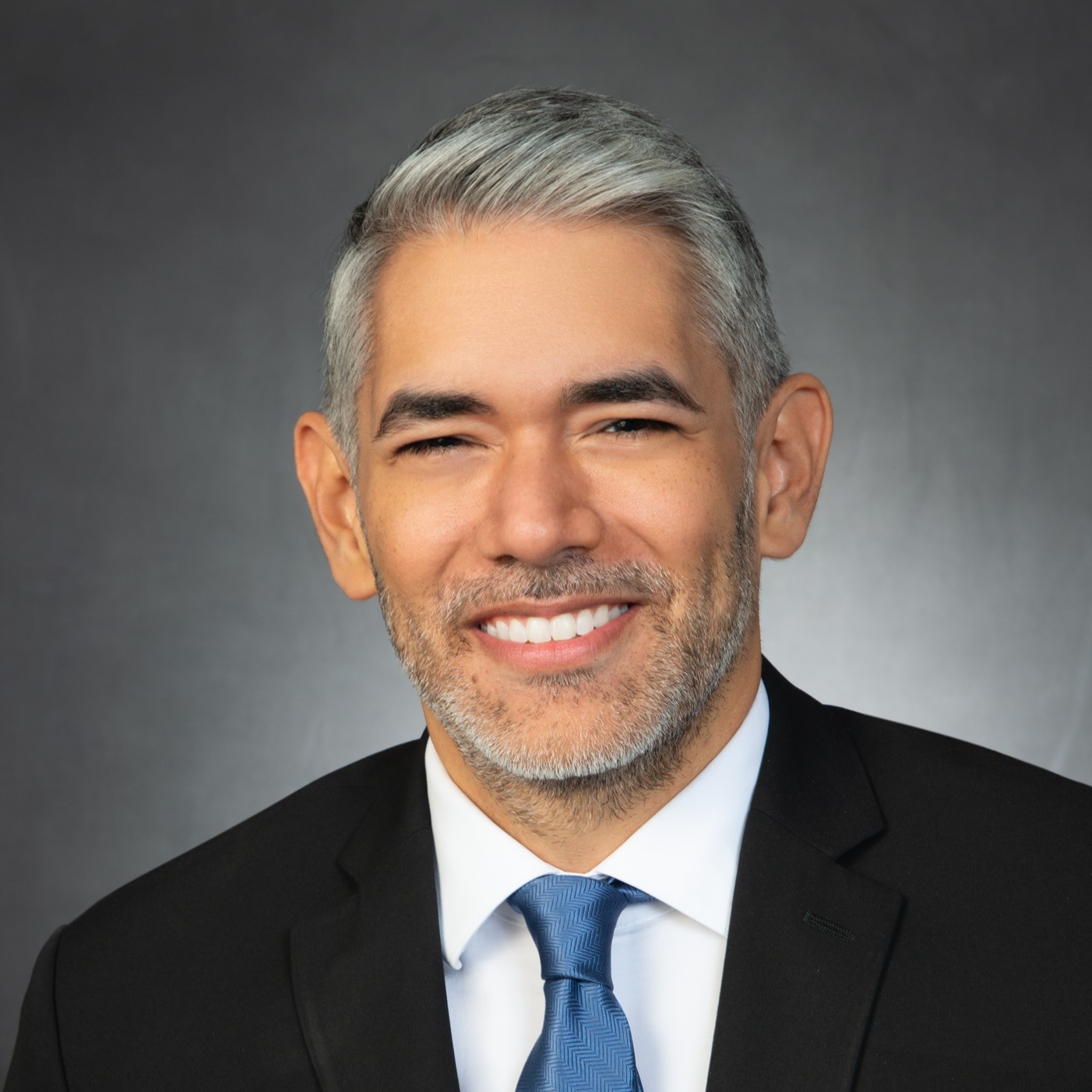 Headshot of Mario Castillo wearing a suit and tie.