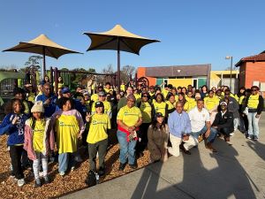 Students, staff, faculty, and community leaders pose for a photo. They are wearing yellow shirts to commemorate the GatorServe event.