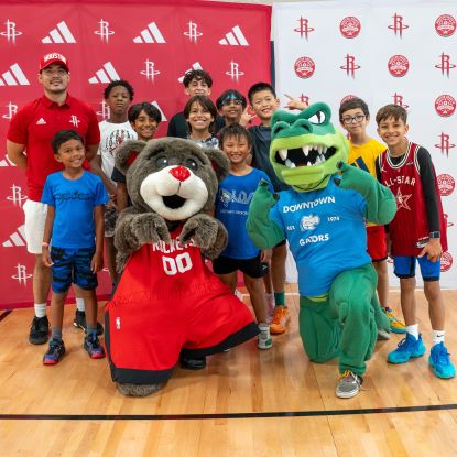 Ed-U-Gator and the Rockets mascot, Clutch, pose for a photo with a group of children attending the Rockets' skills camp at UHD's Wellness & Success Center.