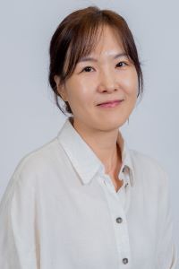 Minkyung Lee wears a white shirt for a headshot photo.