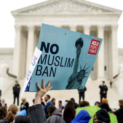 A hand holds up a sign that reads, "No Muslim Ban" outside the US supreme court in Washington DC