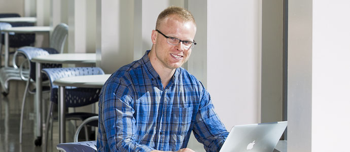 Male student on his laptop for registration