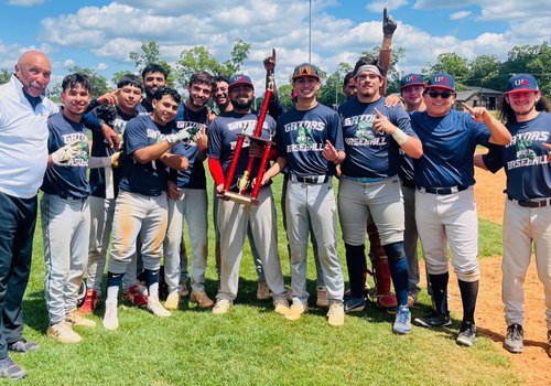 The University of Houston-Downtown's baseball team holds a trophy aside their coach